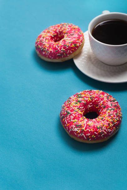 istock A cup of americano with two pink donuts on a blue background 1198405729