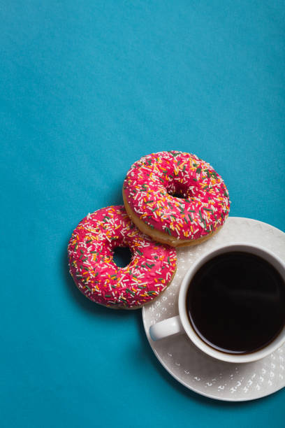 istock A cup of americano with two pink donuts on a blue background 1198405844