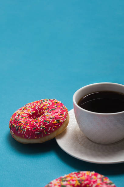 istock A cup of americano with two pink donuts on a blue background 1198405848