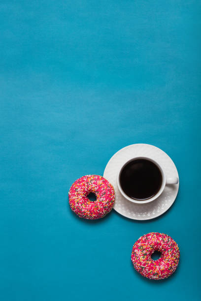 istock A cup of americano with two pink donuts on a blue background 1198405877