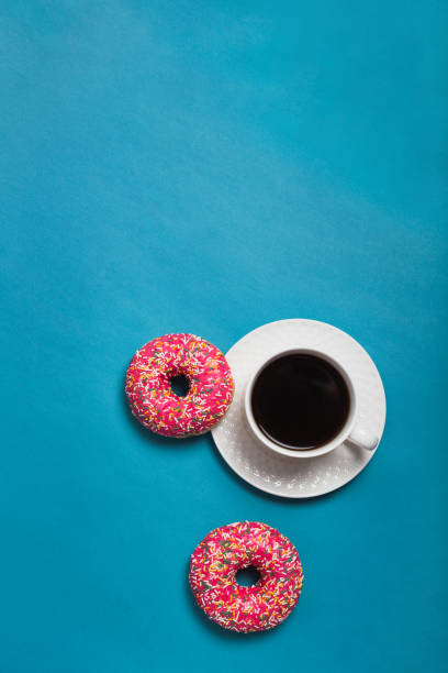 istock A cup of americano with two pink donuts on a blue background 1198405965