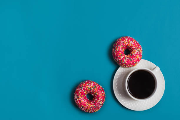 istock A cup of americano with two pink donuts on a blue background 1198405984