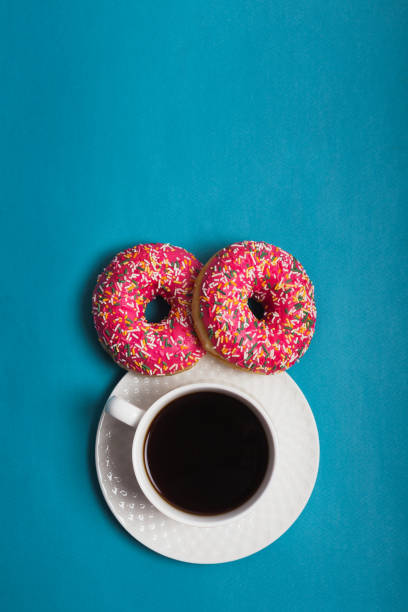 istock A cup of americano with two pink donuts on a blue background 1198405989