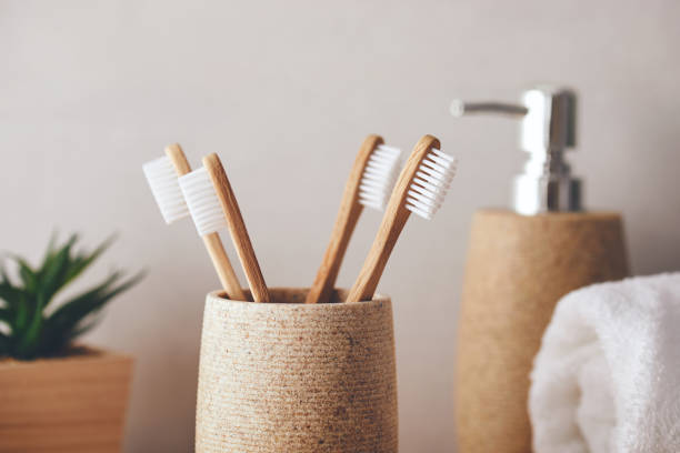 Close up of organic bamboo toothbrushes in the bathroom Close up of four bamboo toothbrushes in a cup toothbrush photos stock pictures, royalty-free photos & images