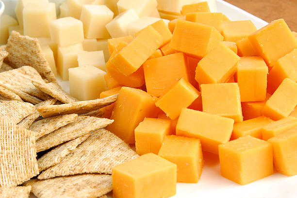 grano cracker e a cubetti di formaggio cheddar e bianco - cheese tray cube swiss cheese foto e immagini stock