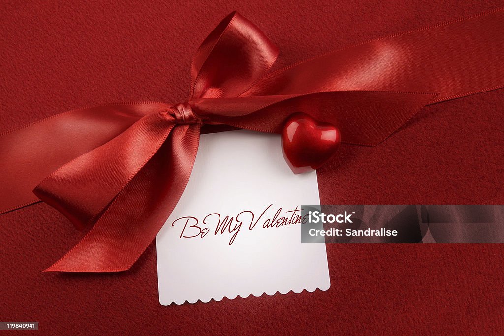 Satin bow and white card for gift on red  Abundance Stock Photo