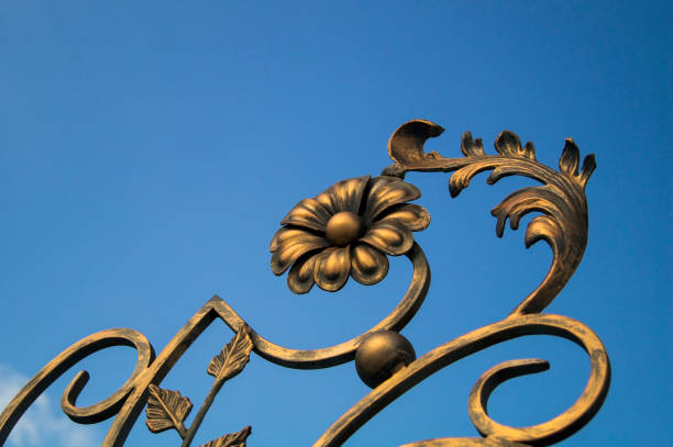 ornate decorative elements of metal gate processing against the blue sky background