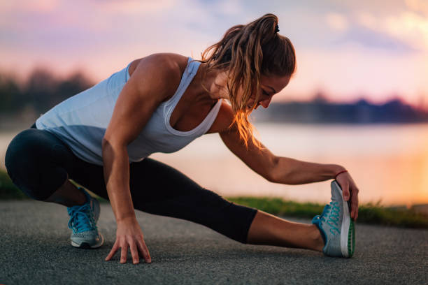 istock Woman Stretching by the Water 1198411825
