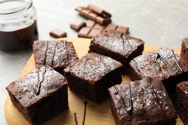 istock Board with chocolate cake slices and chocolate on grey background, close up 1198412979