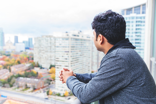 Asian, Admiration, Real People - Asian man admiring views from a high-rise