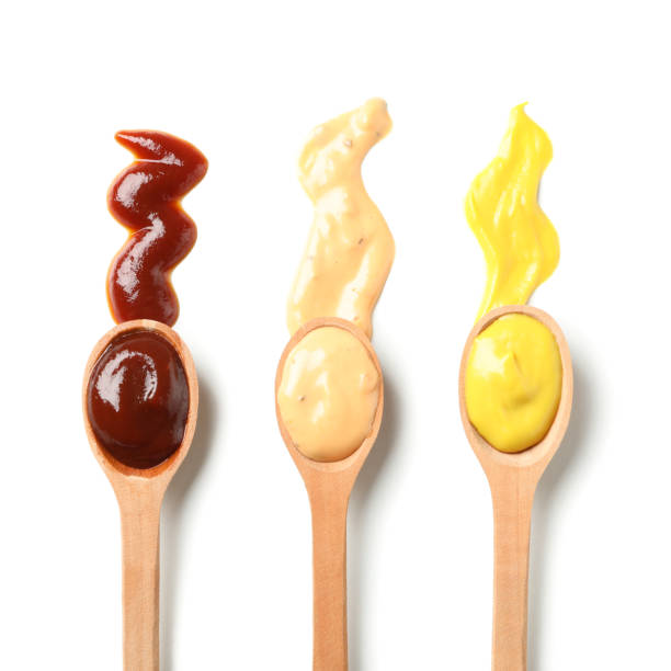 istock Wooden spoons with sauces isolated on white background 1198414871