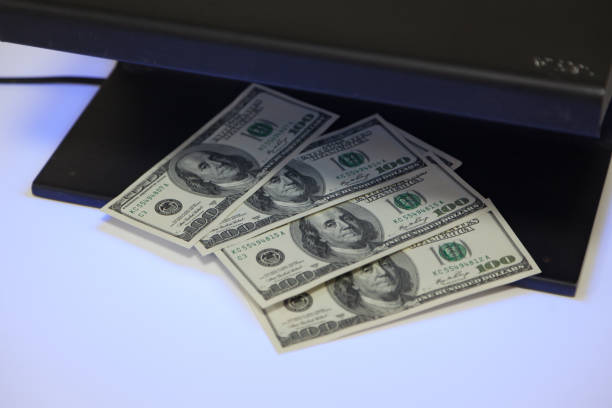 istock Dollar bills lie inside black metal detector 1198415472