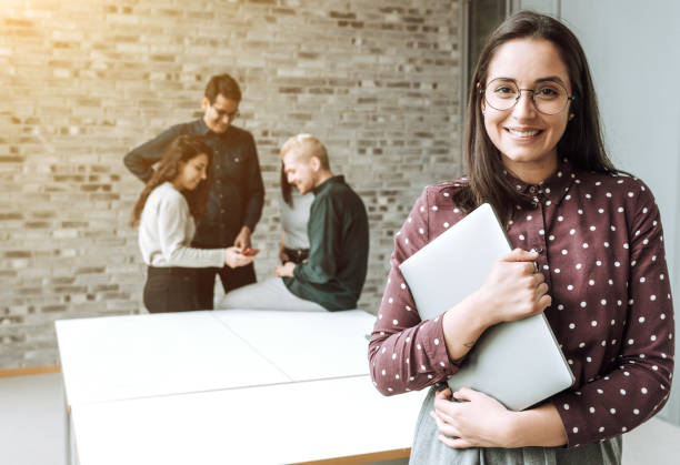 istock Smiling woman with a computer in office 1198416159