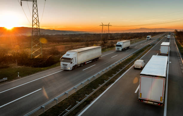 istock Convoys of White transportation trucks passing each other on a highway 1198420719