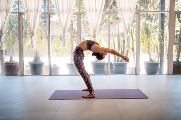 istock Young woman practicing yoga at a studio 1198422288
