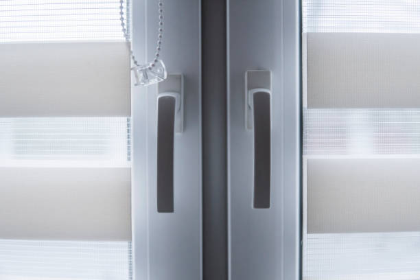 istock Window handle and white fabric roller blinds on the white plastic window in the living room. Close up on roll curtains indoor. 1198423342