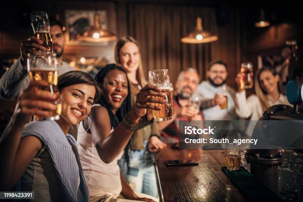 Group Of Friends Drinking Beer At The Bar Stock Photo - Download Image Now - Adult, Adults Only, African Ethnicity