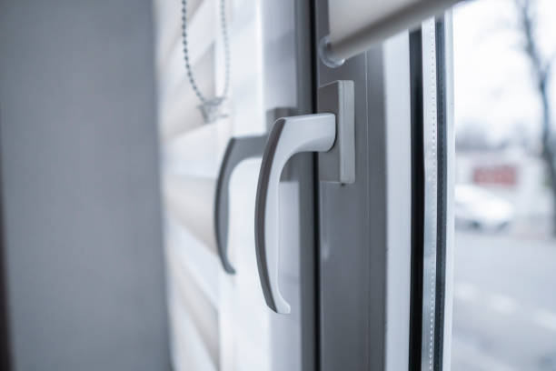 istock Window handle and white fabric roller blinds on the white plastic window in the living room. Close up on roll curtains indoor. 1198426003