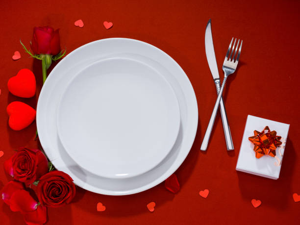 istock Plate, fork, knife and gift box with roses on velvet fabric 1198426951
