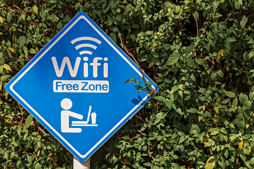 Area sign to use free Wi-Fi. Wireless internet sign on nature background.