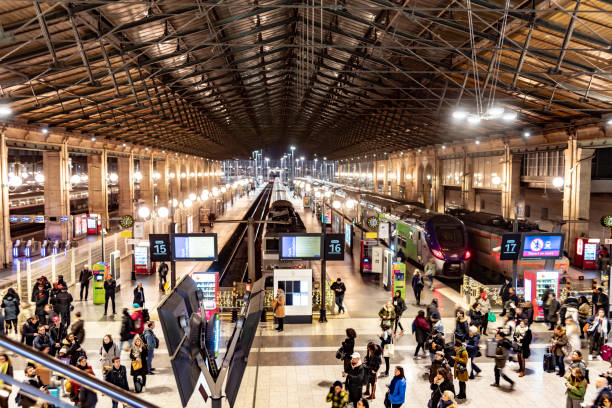 A bustling scene at the U-Bahn train station at Warschauer Straße in Berlin's Kreuzberg district. A large crowd of people can be seen walking through the station, with colorful advertisements and signs lining the walls. The photo showcases the energy and vibrancy of the city, with the hustle and bustle of daily life on full display.