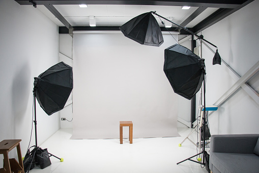 in a photography studio have three umbrella flash light are setting standby for work