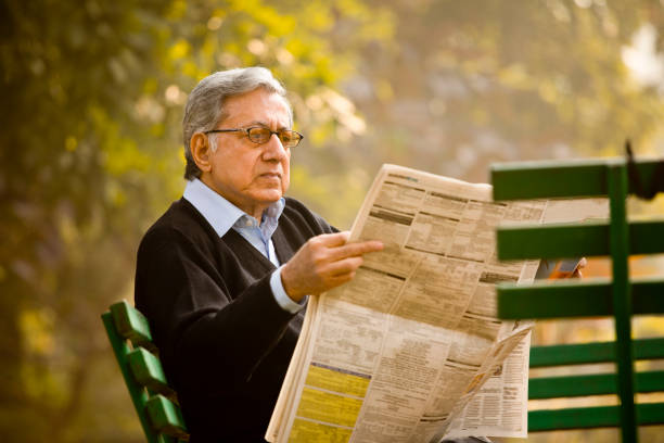 istock Senior man reading newspaper in the park 1198429020