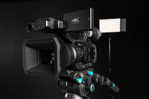 istock Professional 4K video camera on camera tripod and lighting LED panel close-up 1198429946