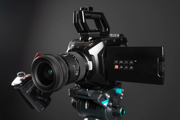 istock Professional video cinema camera on a camera tripod on black background 1198430088