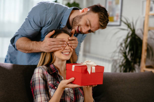 istock A young man covering his girlfriend's eyes for a surprise gift 1198432681