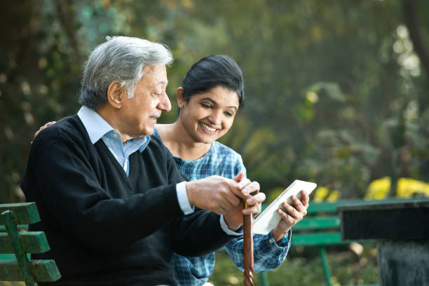 istock Woman with old father using digital tablet at park 1198432749