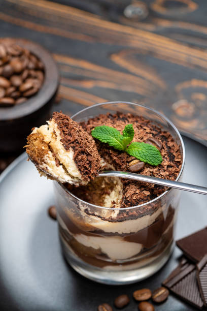 istock Classic tiramisu dessert in a glass cup on wooden background 1198434603