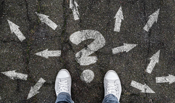 istock person standing on road with arrow markings pointing in different directions 1198434892