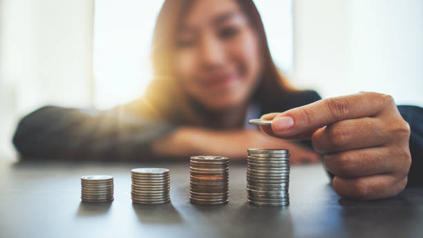 istock Businesswoman holding and stacking coins 1198436250