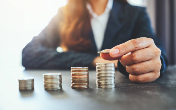 istock Businesswoman holding and stacking coins 1198436277