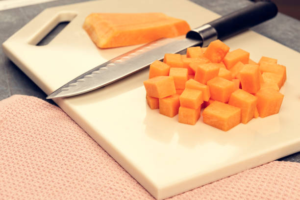 istock Slicing pumpkin on a cutting kitchen board made of artificial stone 1198438538