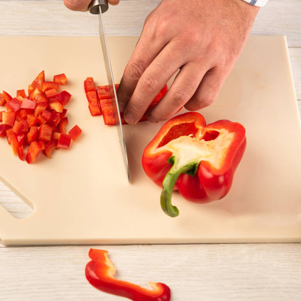 istock A section of bell pepper with a sharp knife on a cutting board made of artificial stone 1198438554