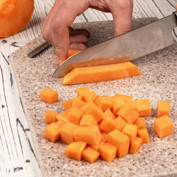 Slicing pumpkin on a cutting kitchen board made of artificial stone