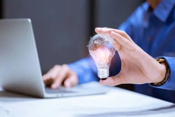 Photo of Business hand holding light bulb,with brain icon,creativity and innovative are keys to success,new ideas and innovation concep