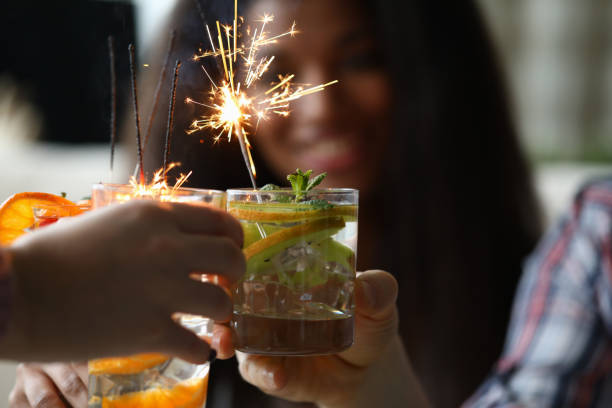 istock Young group friends hold in hand cocktail with sparkler 1198446035