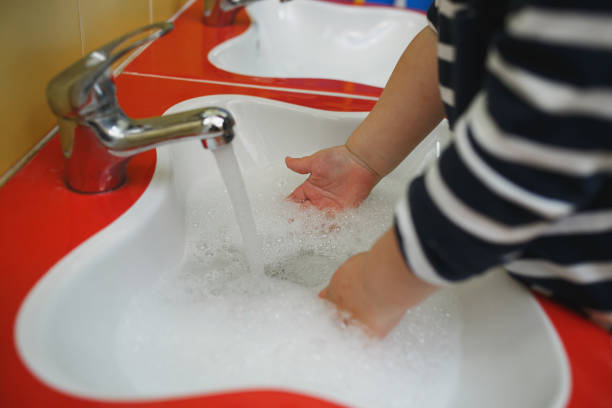 maluchy myją ręce w myjni w przedszkolu. pojęcie higieny, profesjonalnej opieki nad dziećmi - washstand zdjęcia i obrazy z banku zdjęć