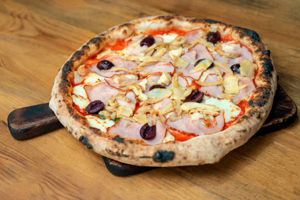 istock Freshly baked pizza with ingredients on a wooden table 1198447300