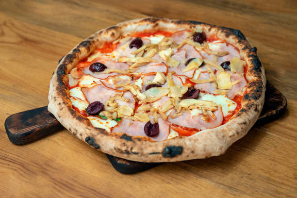 istock Freshly baked pizza with ingredients on a wooden table 1198447497
