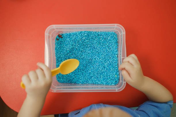 Children play educational games with a sensory bin in kindergarten