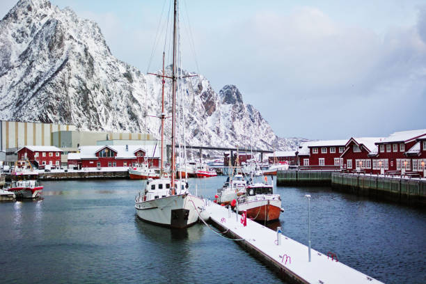 Svolvaer harbor with boats and red rorbu with snowy mountains on background. Svolvaer harbor with boats harbor of svolvaer in winter lofoten islands norway stock pictures, royalty-free photos & images
