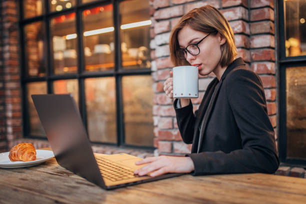 istock Young woman is using laptop over breakfast 1198453784