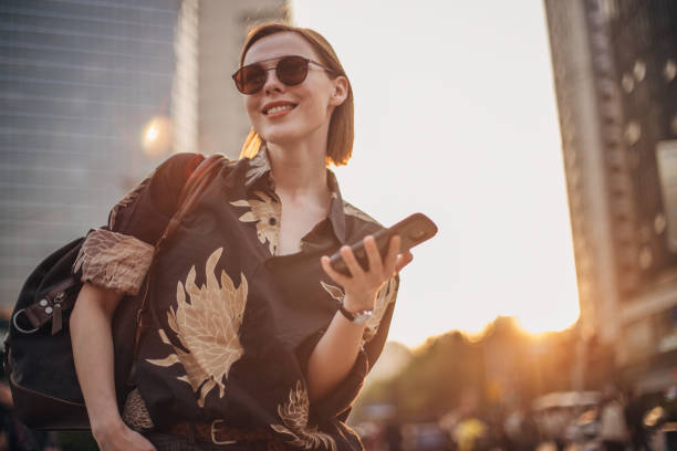 istock Stylish young woman is text messaging 1198454512