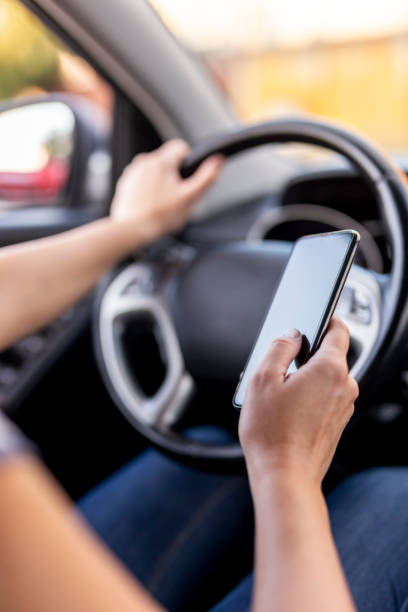 istock Woman driving a car and using a phone 1198459137