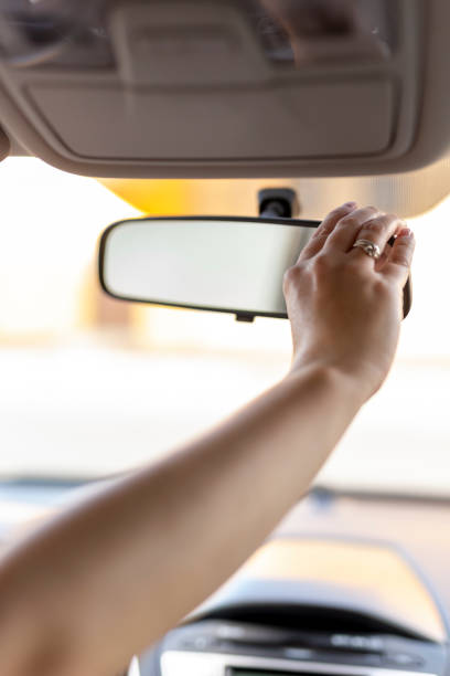 istock Woman adjusting rearview mirror in the car 1198459302