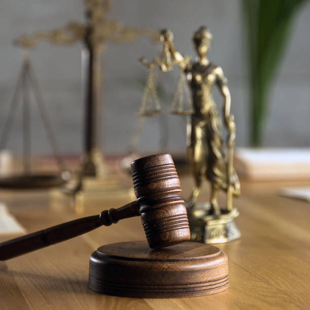 Symbol of law and justice on wooden table in lawyer office stock photo